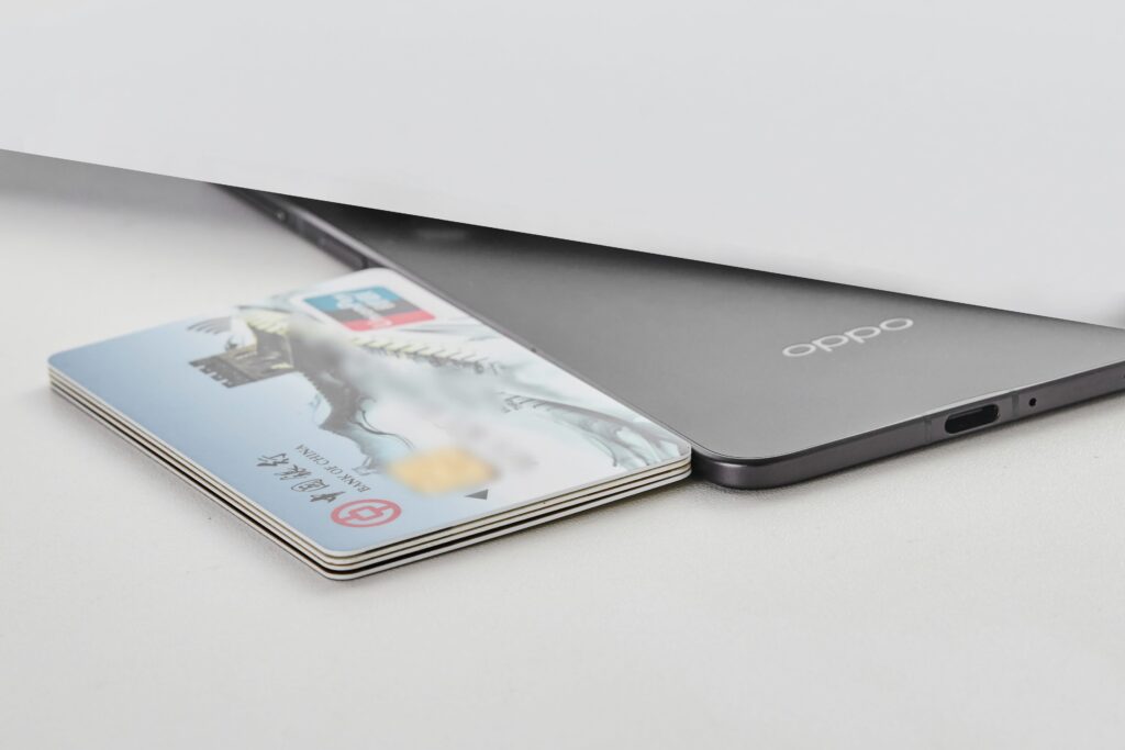 OPPO Find N5 placed alongside stacked bank cards, highlighting its thin profile and compact build.