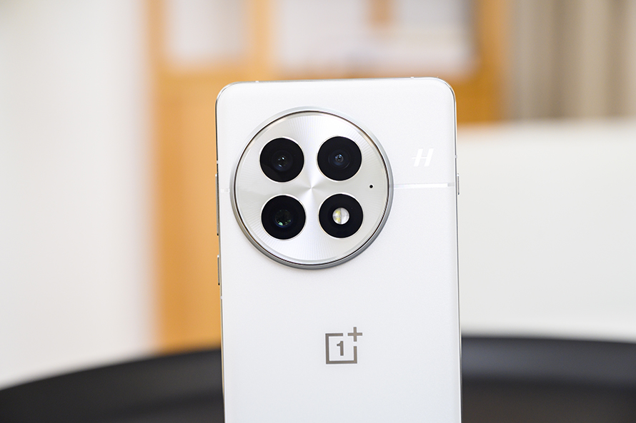 Close-up of the OnePlus 13’s circular camera module in a pristine white finish, showcasing its modern aesthetic.