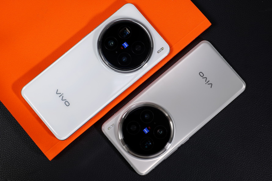 Two Vivo X200 Pro smartphones placed on a black and orange surface, highlighting the premium finish and innovative camera design.