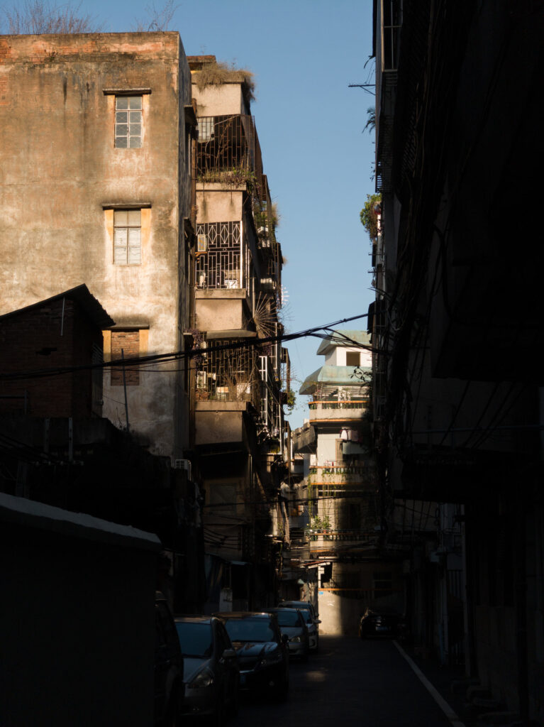 An urban alleyway with aged buildings and shadows, capturing textures and a nostalgic atmosphere.