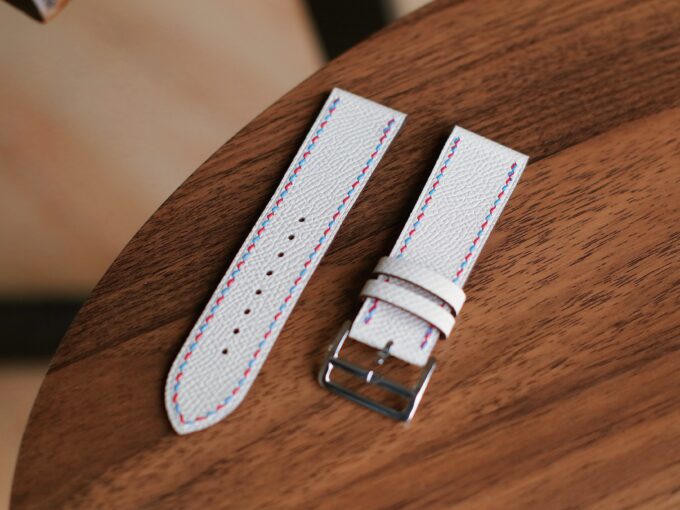 Top-down view of the white leather Apple Watch band segments, with the buckle and connectors visible.