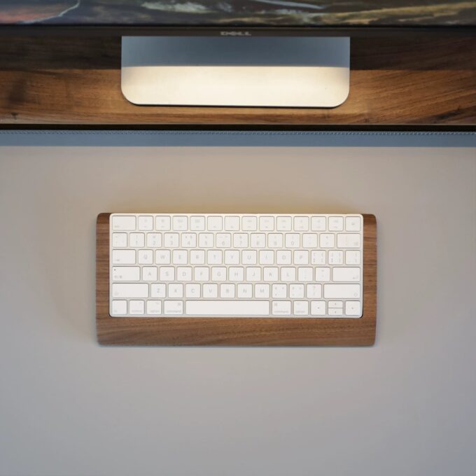 Elegant desk layout with a Magic Keyboard placed on a premium wooden wrist rest tray, perfectly complementing the workspace’s natural tones.