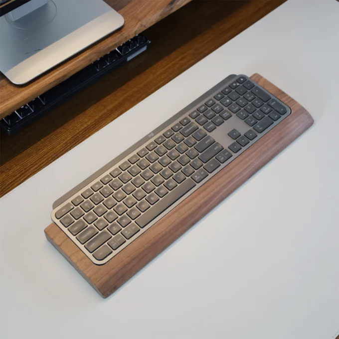 Angled perspective of the Walnut Wood Wrist Rest Tray with a keyboard, emphasizing its ergonomic profile and seamless fit.