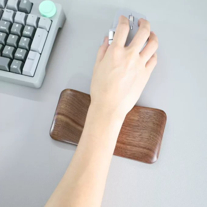 A person’s hand resting on the Artisan Wood Ergonomic Mouse Wrist Rest, illustrating its ergonomic support in use.