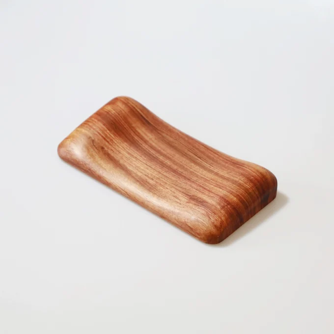 Another Artisan Wood Ergonomic Mouse Wrist Rest in a darker wood tone, placed on a white tabletop for contrast.