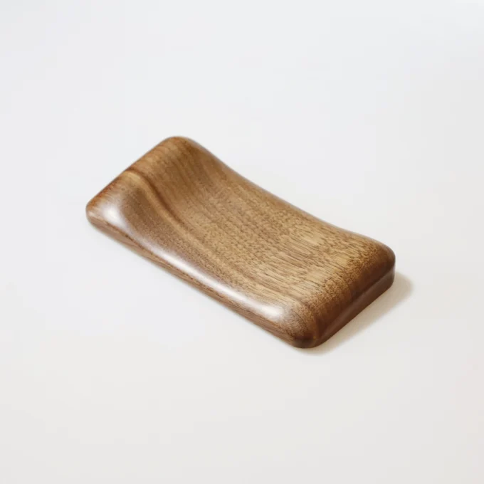 The Artisan Wood Ergonomic Mouse Wrist Rest alone on a white surface, featuring a lighter wood finish with a gentle curve.