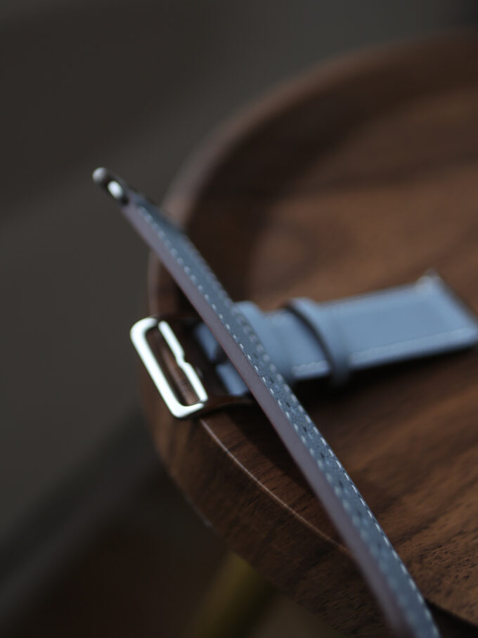 Detail of the band’s edge, emphasizing the neat, reinforced stitching where blue meets tan leather