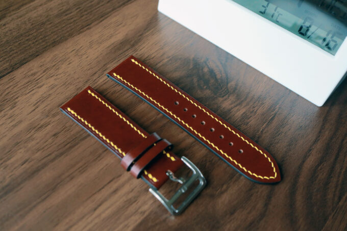 Close-up view of the band’s two pieces—one with a stainless steel buckle, the other longer strap—highlighting the smooth leather texture.