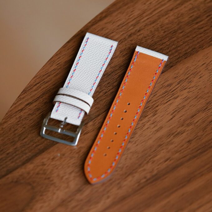 Close-up of the white strap’s perforations, showcasing the smooth leather surface and subtle stitching.