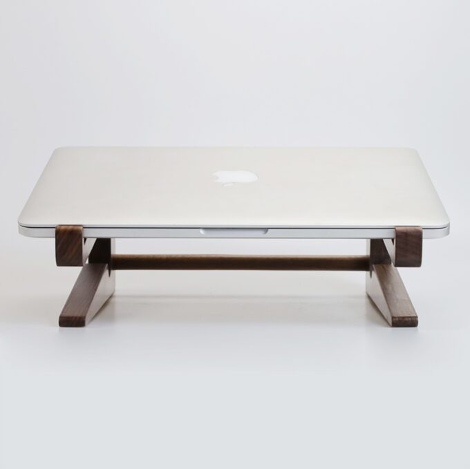 The walnut DualMode MacBook Stand displayed empty, showing its minimalist frame and angled support rods.