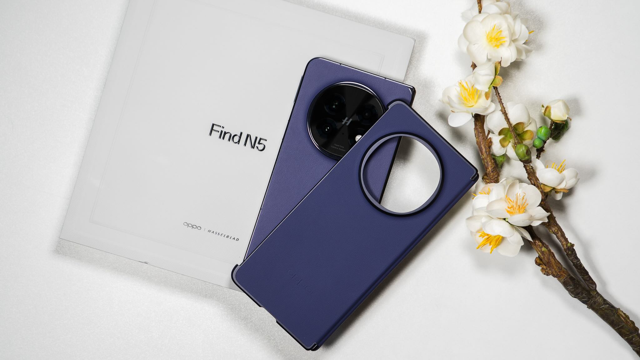 A purple blue protective case with a circular camera cutout placed on top of OPPO Find N5 packaging.