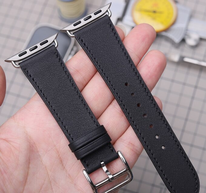 Two black French Swift Leather Apple Watch straps held together, revealing the hypoallergenic stainless steel adapters and buckle.