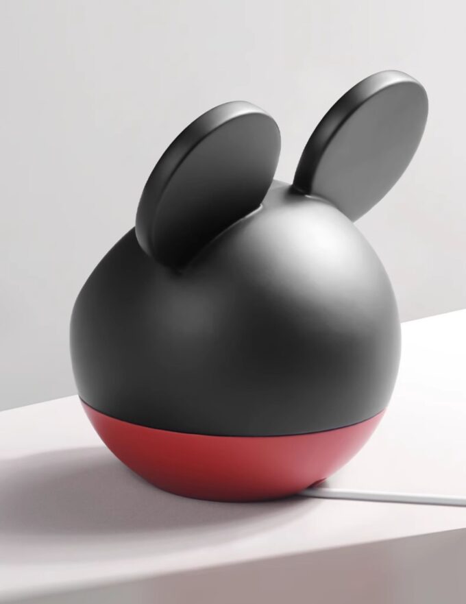 Side view of the spherical charging dock showing its black top, red base, and ear-shaped accents.