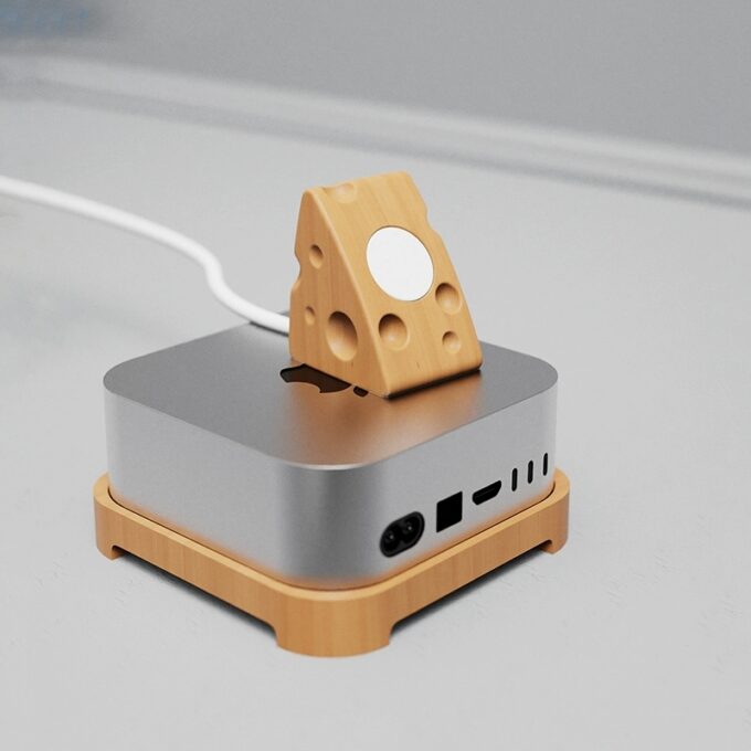 A minimalist beech wood Apple Watch stand positioned on top of a Mac Mini, highlighting its space-saving design.