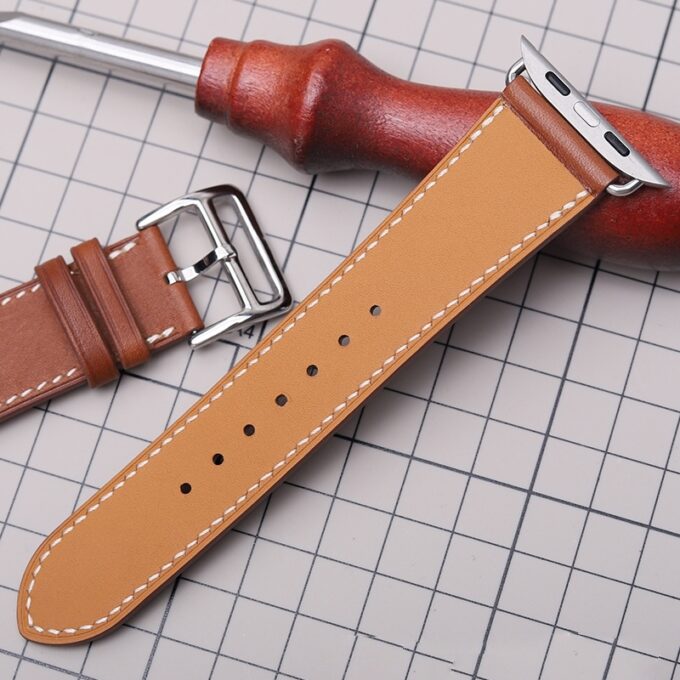 Tan French Swift Leather Apple Watch band placed on a grid mat, showing off its smooth finish and precise stitching.