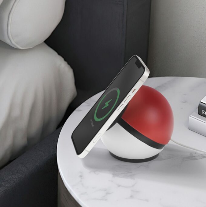 The ball-shaped dock on a nightstand with a phone attached, showcasing convenient bedside charging.