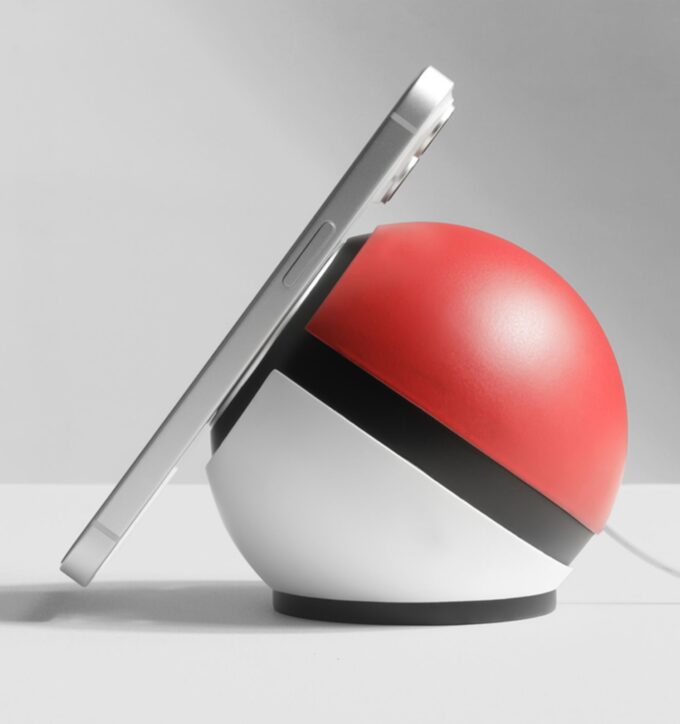 An iPhone propped against the spherical dock at a slight tilt, demonstrating its stable charging position.