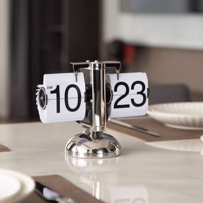 A classic white mechanical flip clock displayed against a neutral background, emphasizing its timeless design.