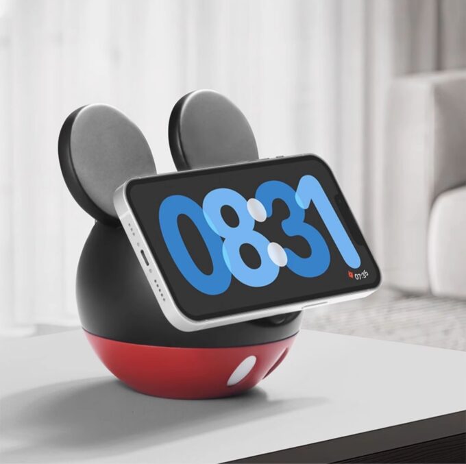 A whimsical black-and-red charger with mouse-like ears holding a phone horizontally, displaying the time “08:31.”