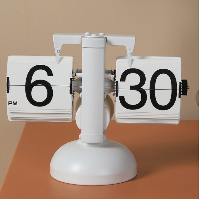 A minimalist white mechanical flip clock with a clean design, placed on a warm-toned desk for an elegant and timeless appearance.