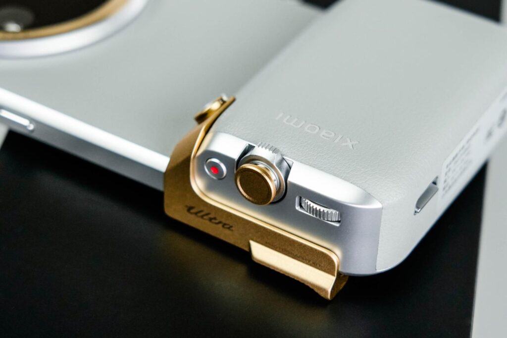 Xiaomi 15 Ultra with a gold-accented camera grip accessory for professional photography.